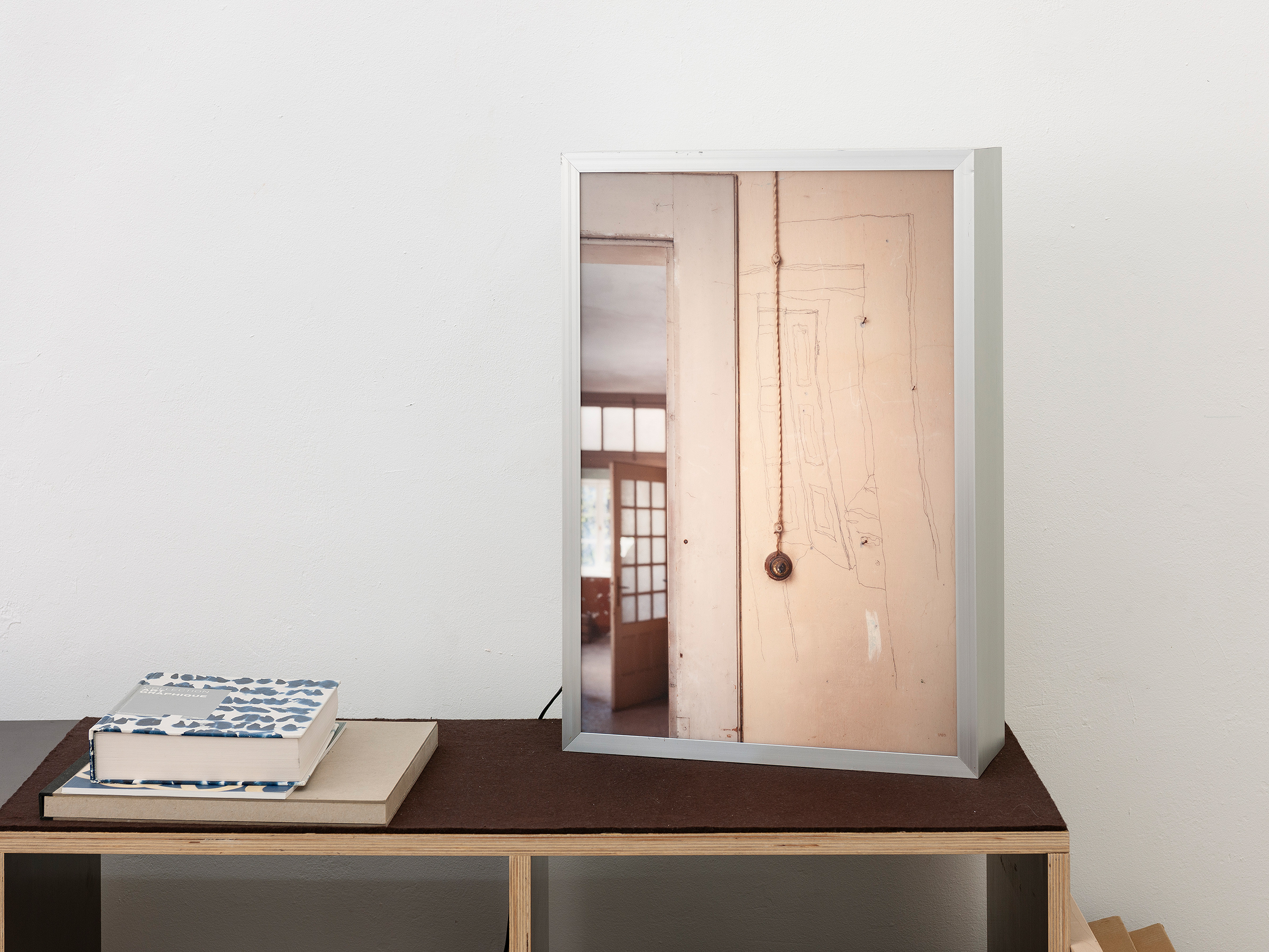 Paul Thuile || Priamistrasse 7 Ausstellungsansicht Kunstwerk mit der Ansichtaus einem Raume platziert auf einer Bank rechts im Bild