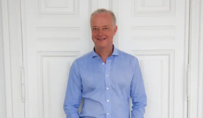 eine Ganzkörperaufnahme von Thomas Rusche vor einer Tür